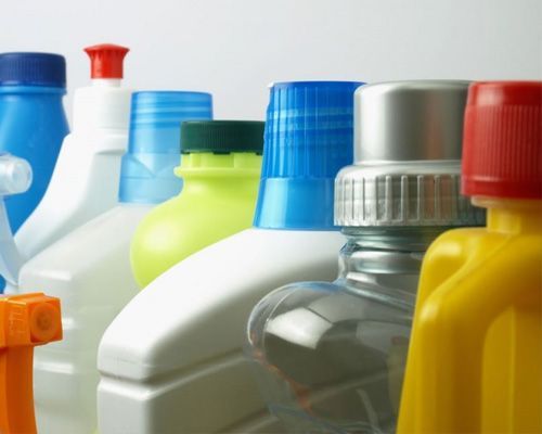 Several bottles of cleaning supplies are lined up in a row