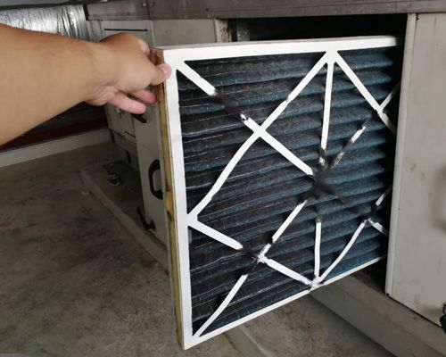 A person is holding a filter out of a drawer.
