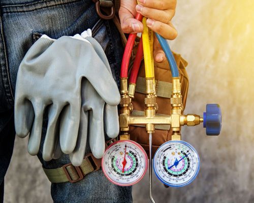 A man is holding a bag of tools and a pair of gloves.