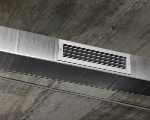 A stainless steel air vent is hanging from the ceiling of a building.