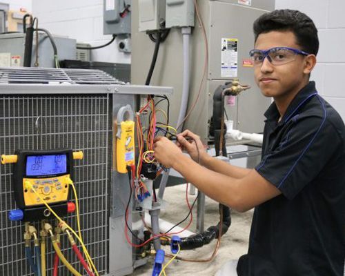 Arctic Fox technician is working on an air conditioner in a factory.
