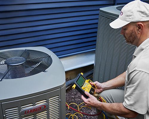 A man is working on an air conditioner outside of a building.