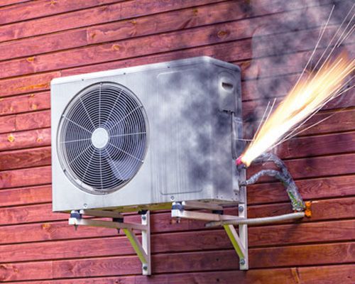 A fire is coming out of an air conditioner on a wooden wall.