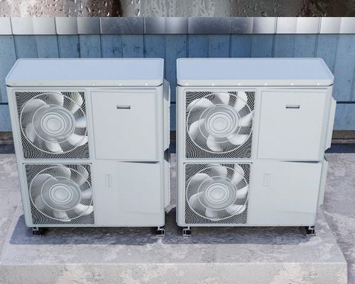 Two air conditioners are stacked on top of each other on a concrete surface.
