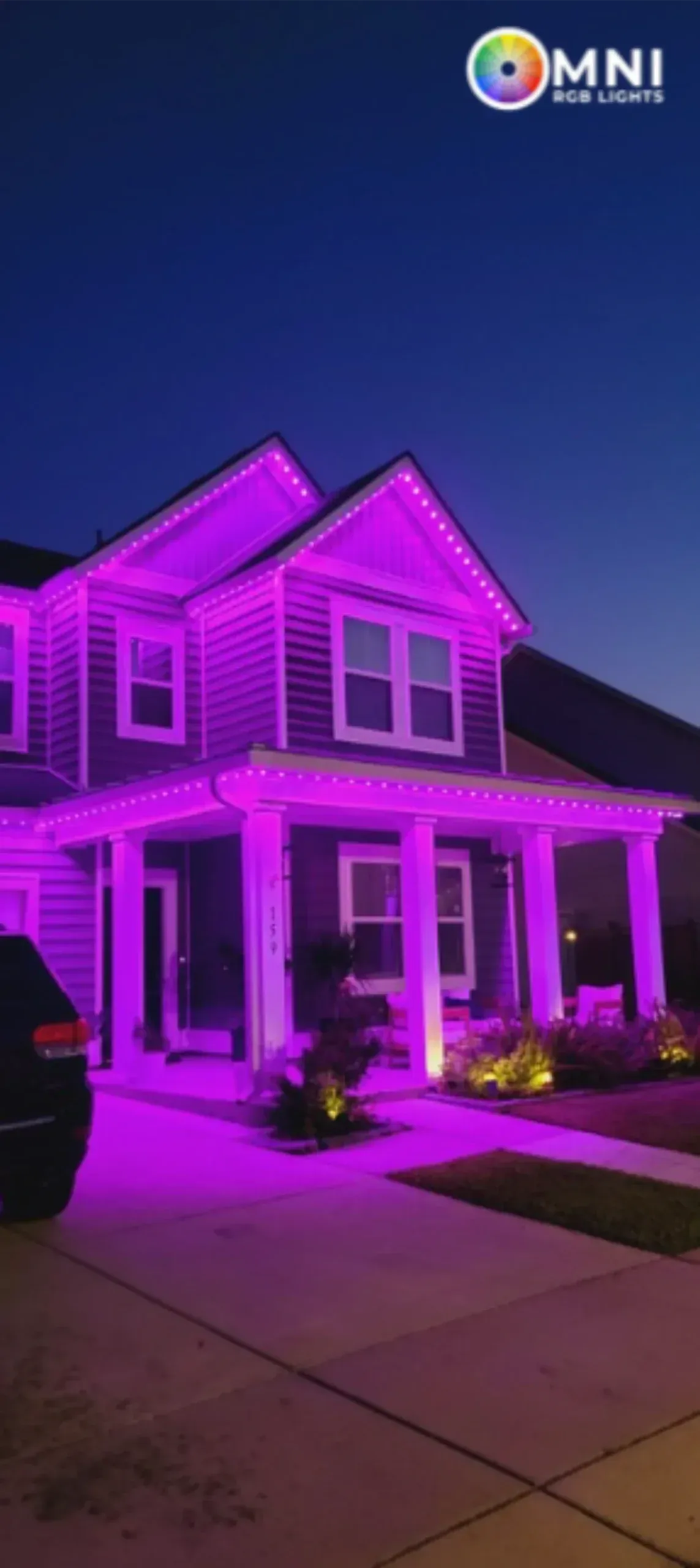 Suburban house lit with vivid purple accent lights at night