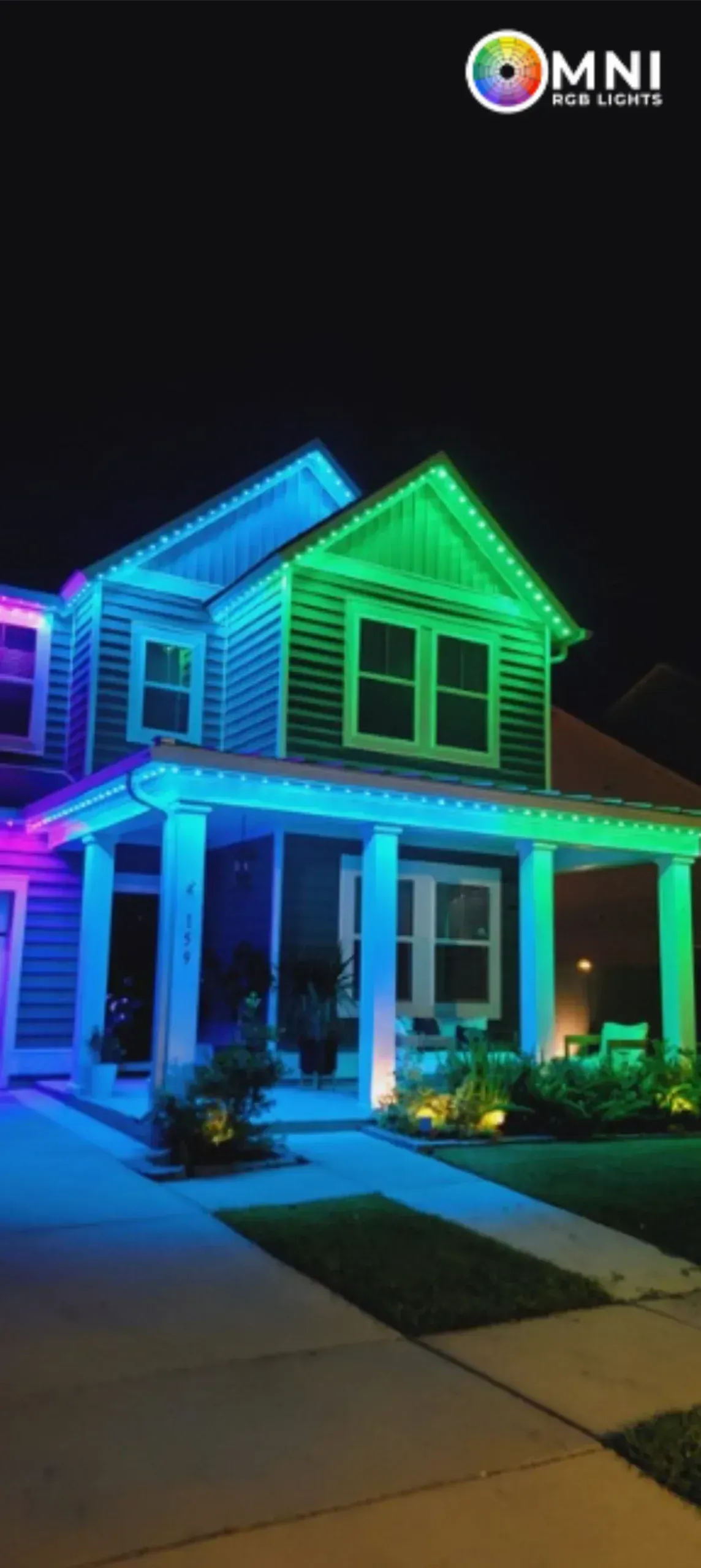 House outlined with bright blue, green, and purple neon lights at night, viewed from the street