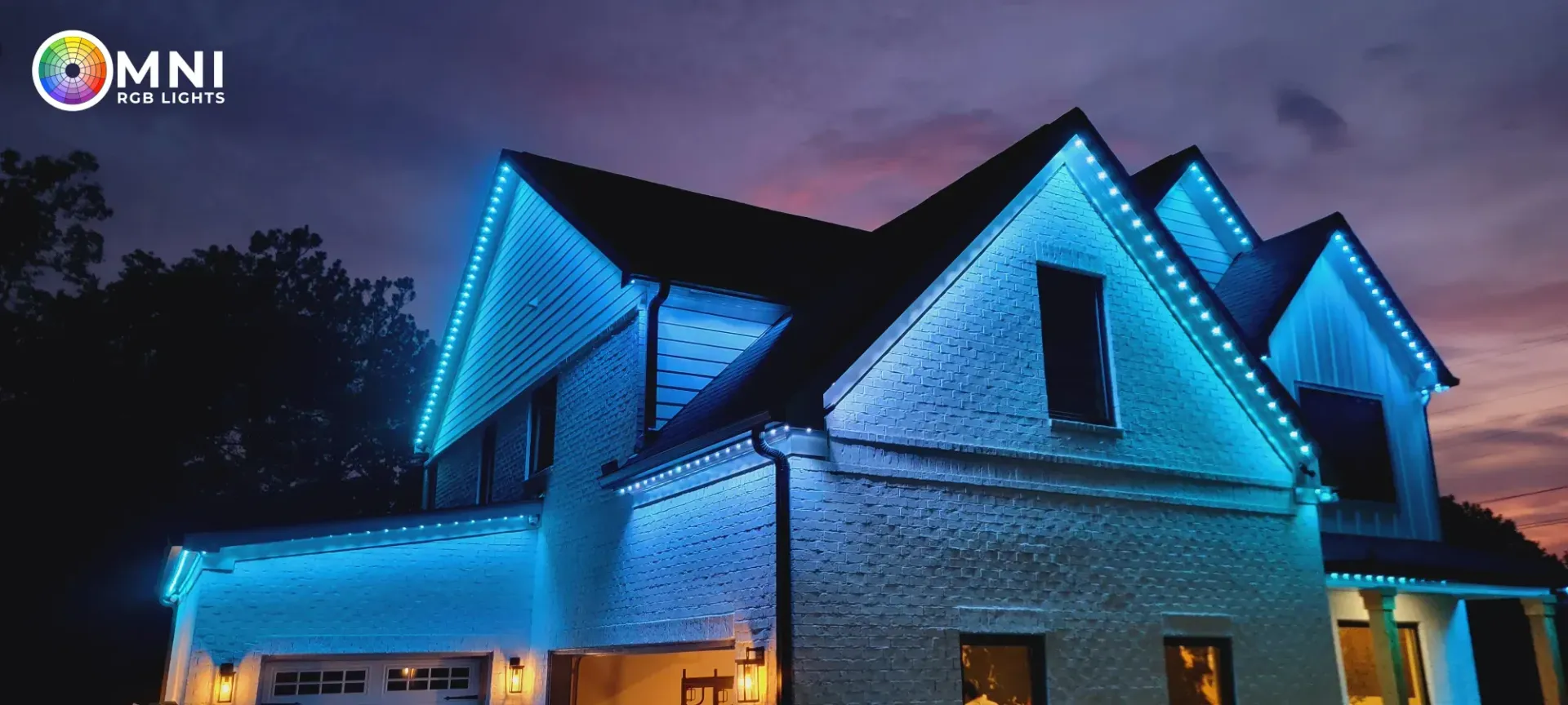 Blue-lit suburban house at night with dark roof and glowing windows
