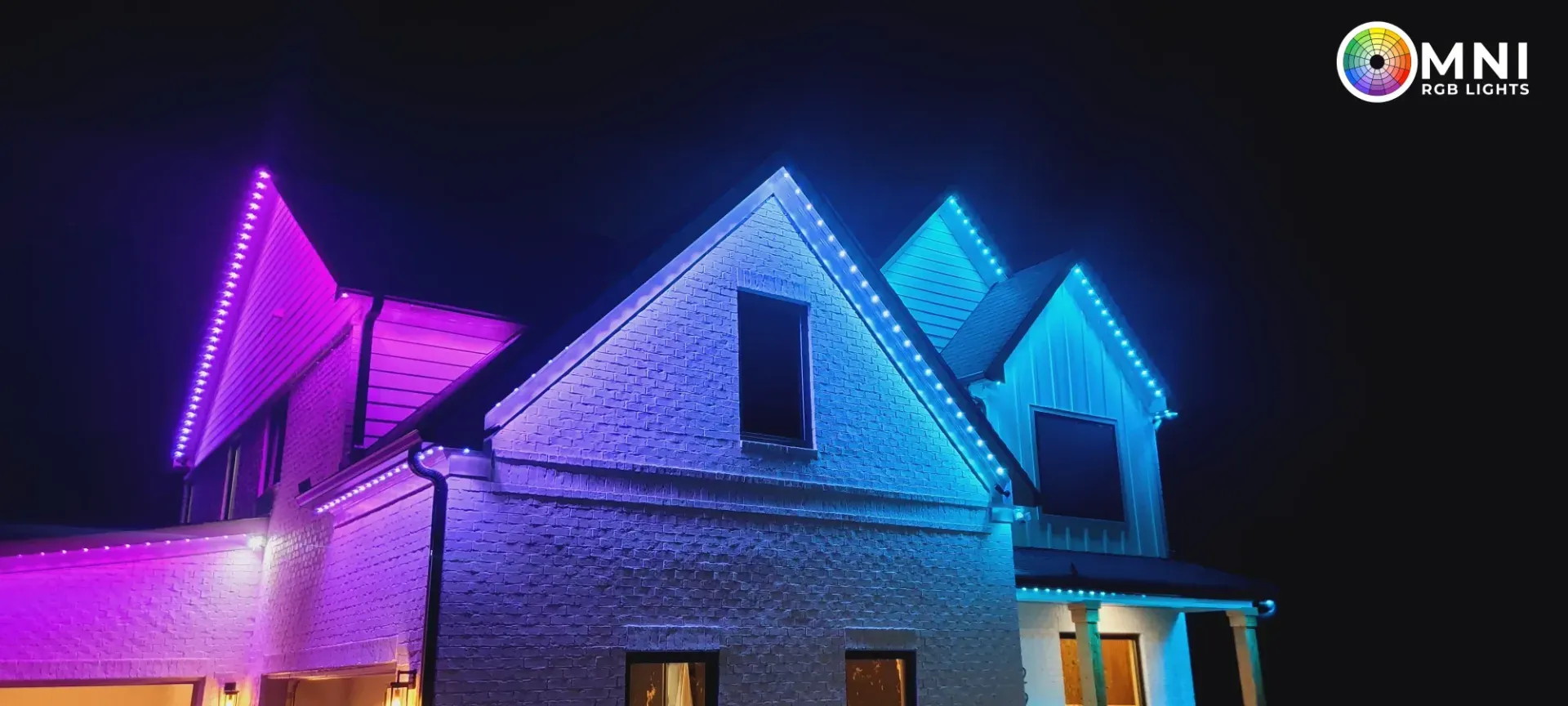 House with purple and blue holiday lights at night
