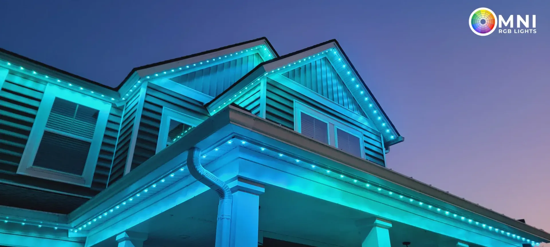 Blue-lit house exterior with peaked roof and bright trim at dusk