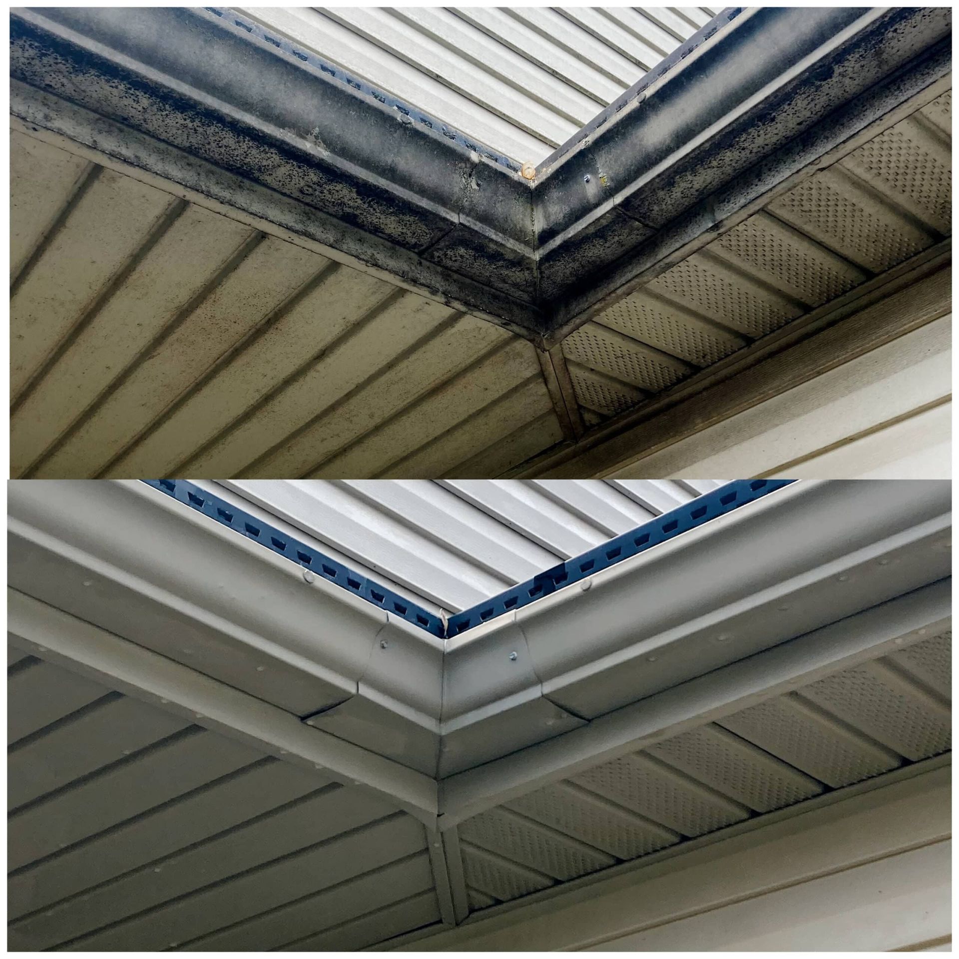 Upward view of two roof skylights and dusty white ceiling beams forming a corner