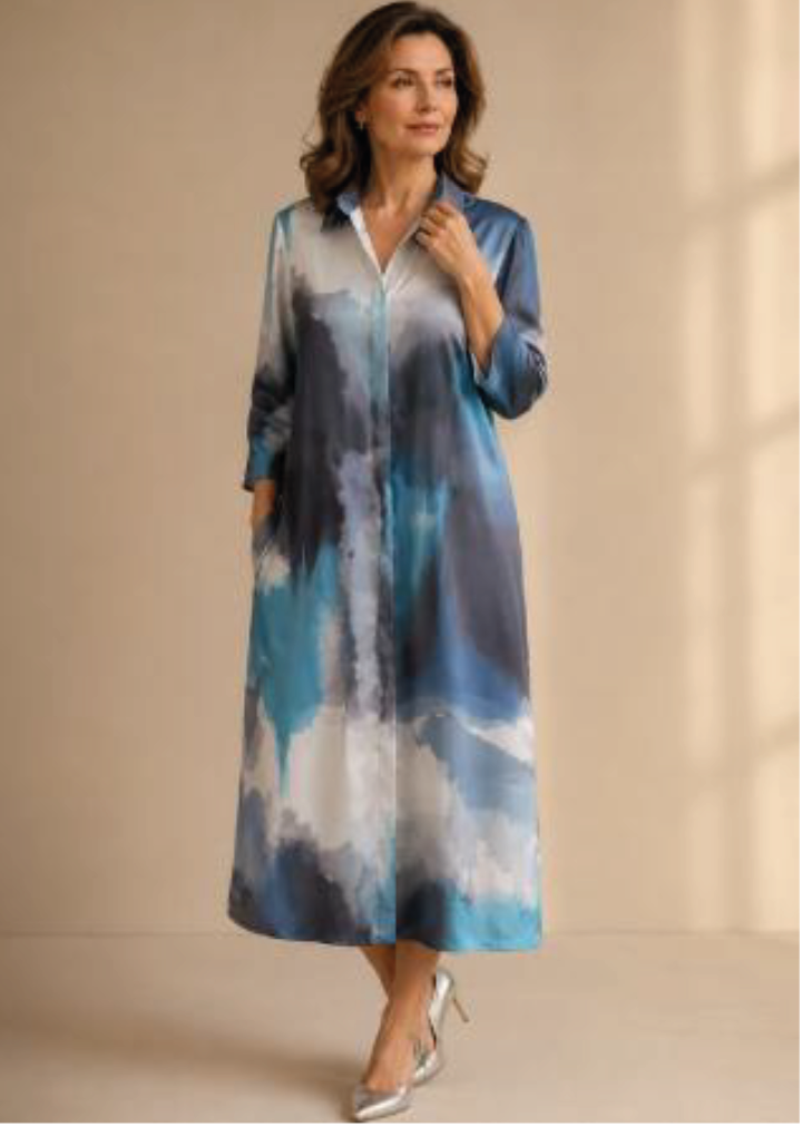Mujer con un vestido azul y blanco estilo acuarela posando contra una pared beige.