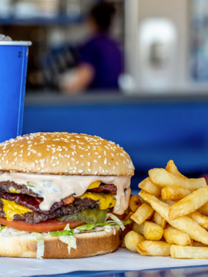Burger and fries on a tray at a casual restaurant counter with a blurred background