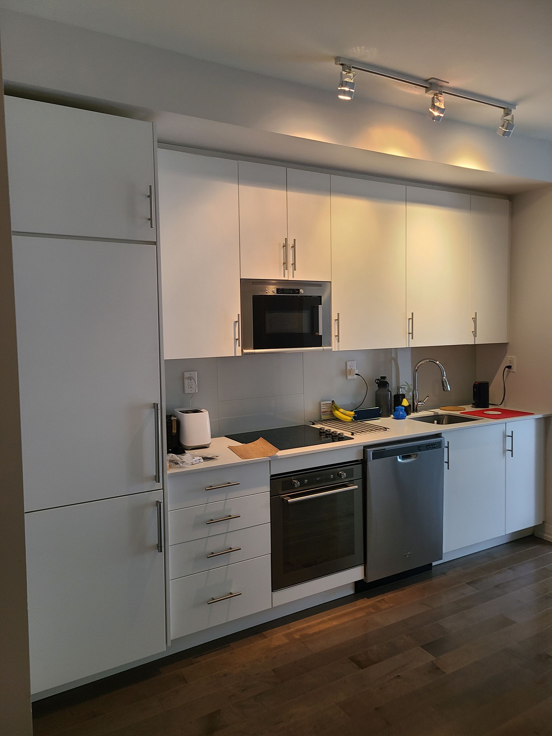 White kitchen cabinets and appliances in a modern setting.