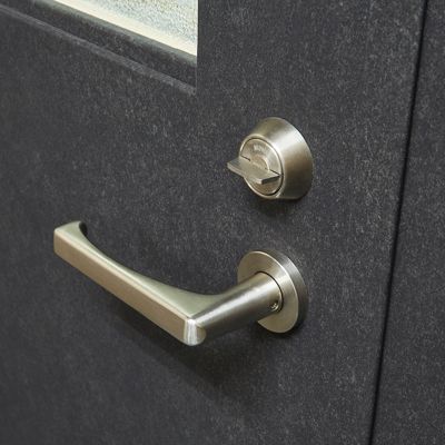 Brushed metal door handle and keyed lock on a dark grey door.