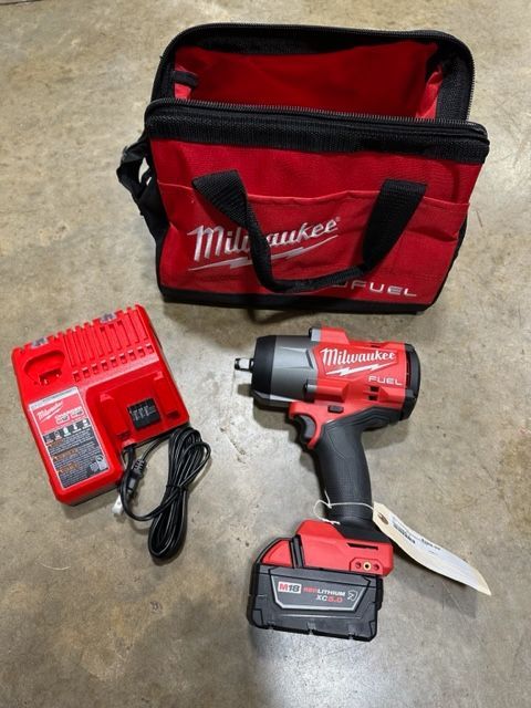 A milwaukee cordless drill with a charger and bag