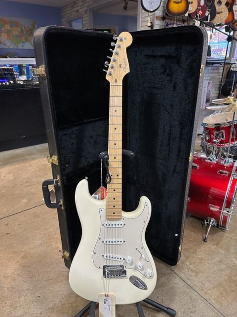 A white electric guitar is sitting in a case