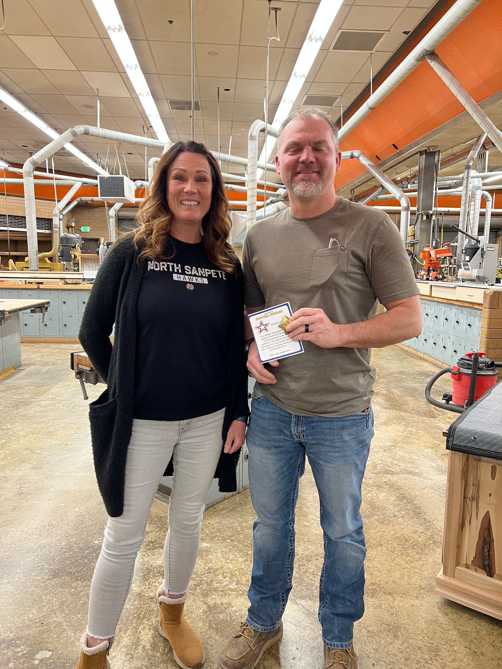 A man and a woman are standing next to each other in a factory.