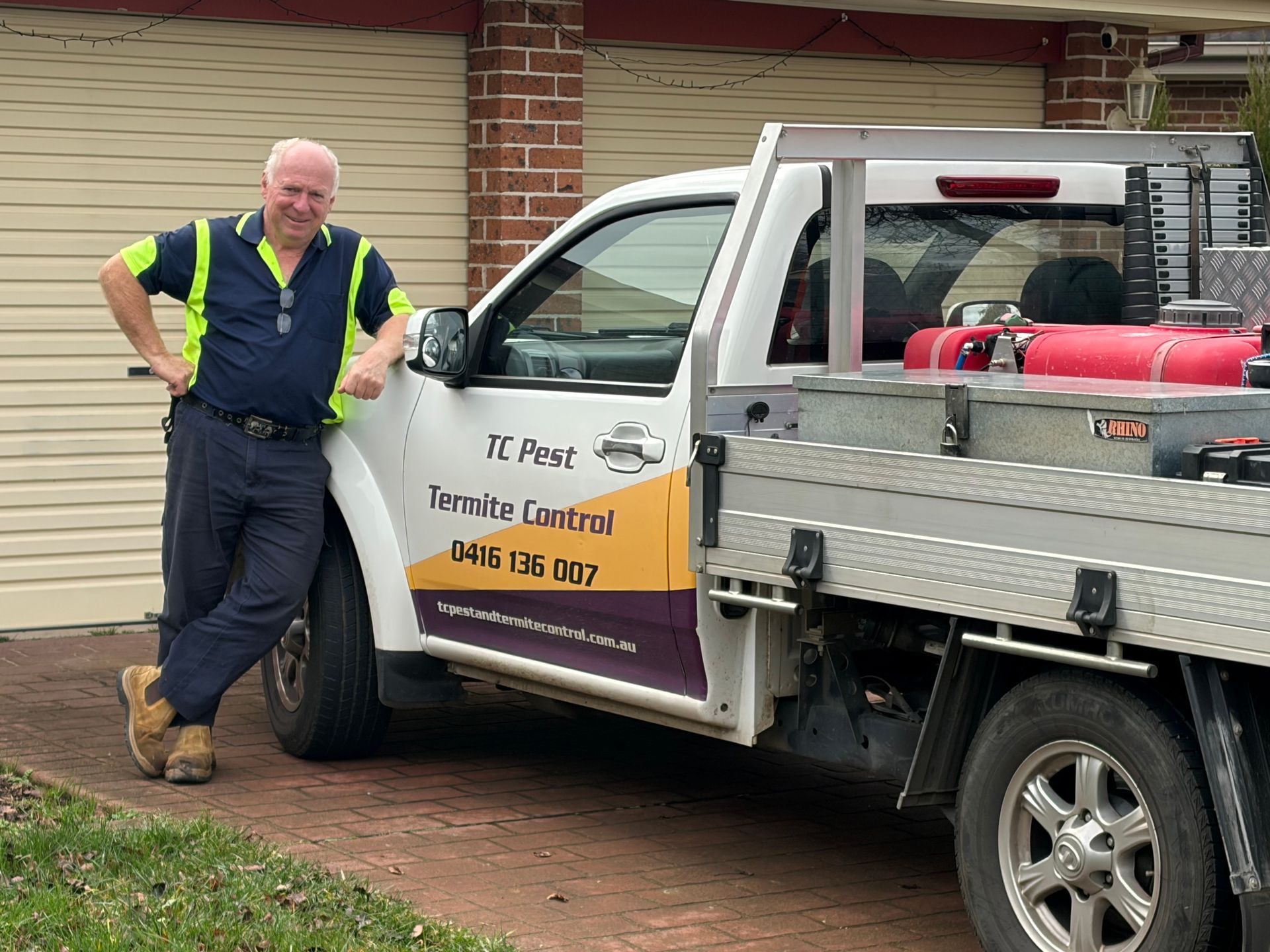 Tony in his hi-vis vest leaning on a white Ute with TC Pest Termite Control written on it — TC Pest & Termite Control In Bowral, NSW