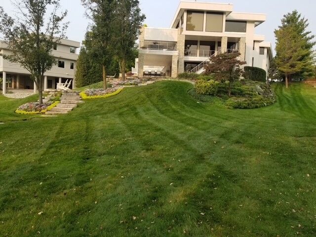 A large house with a lush green, freshly cut lawn in front of it