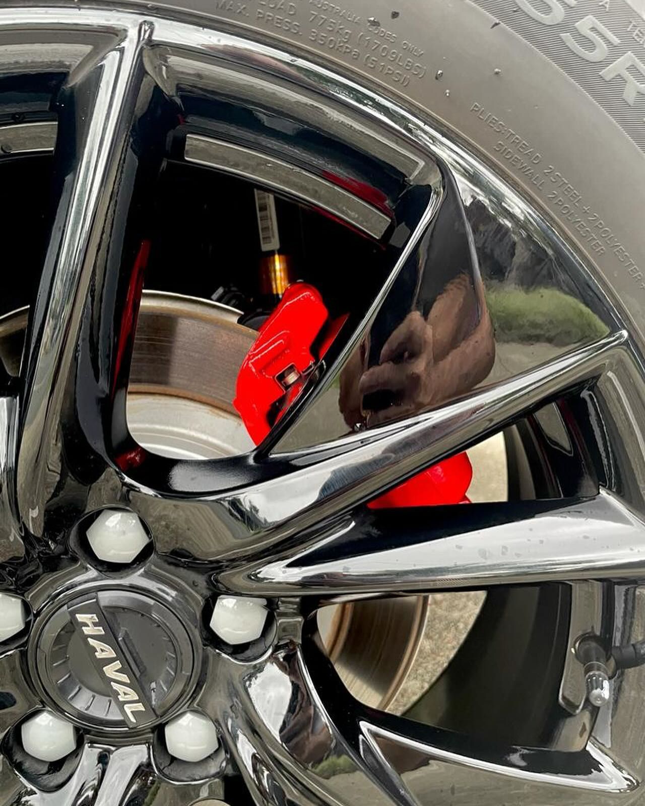 Close-up of a black Haval car wheel with a red brake caliper. — Coolum Smash Repairs in Coolum Beach, QLD