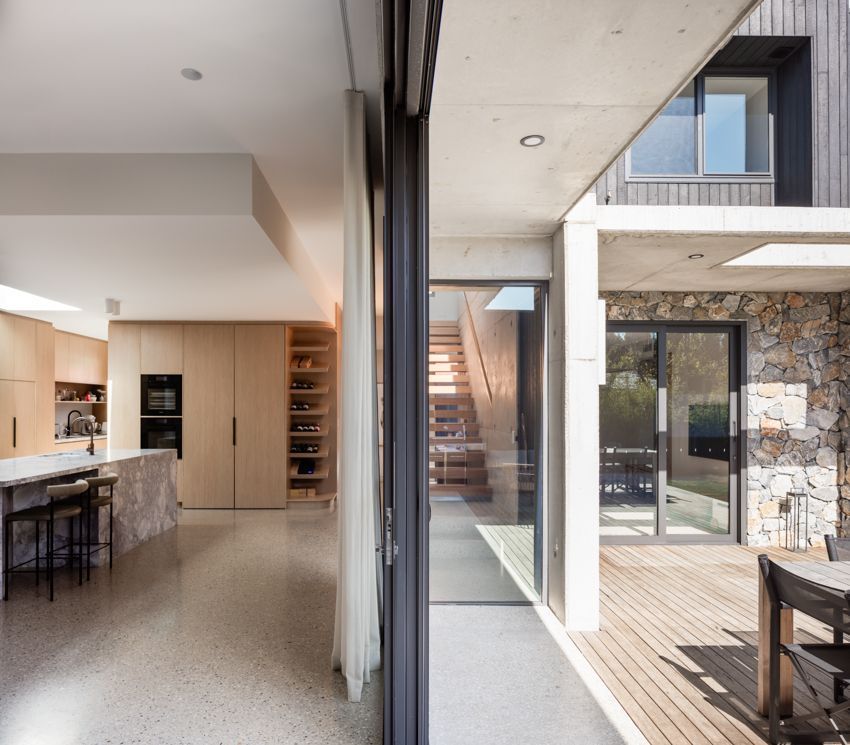 Modern home interior with kitchen, dining area, and outdoor deck visible through glass sliding doors — Make The Mark Building Services in Illawarra, NSW