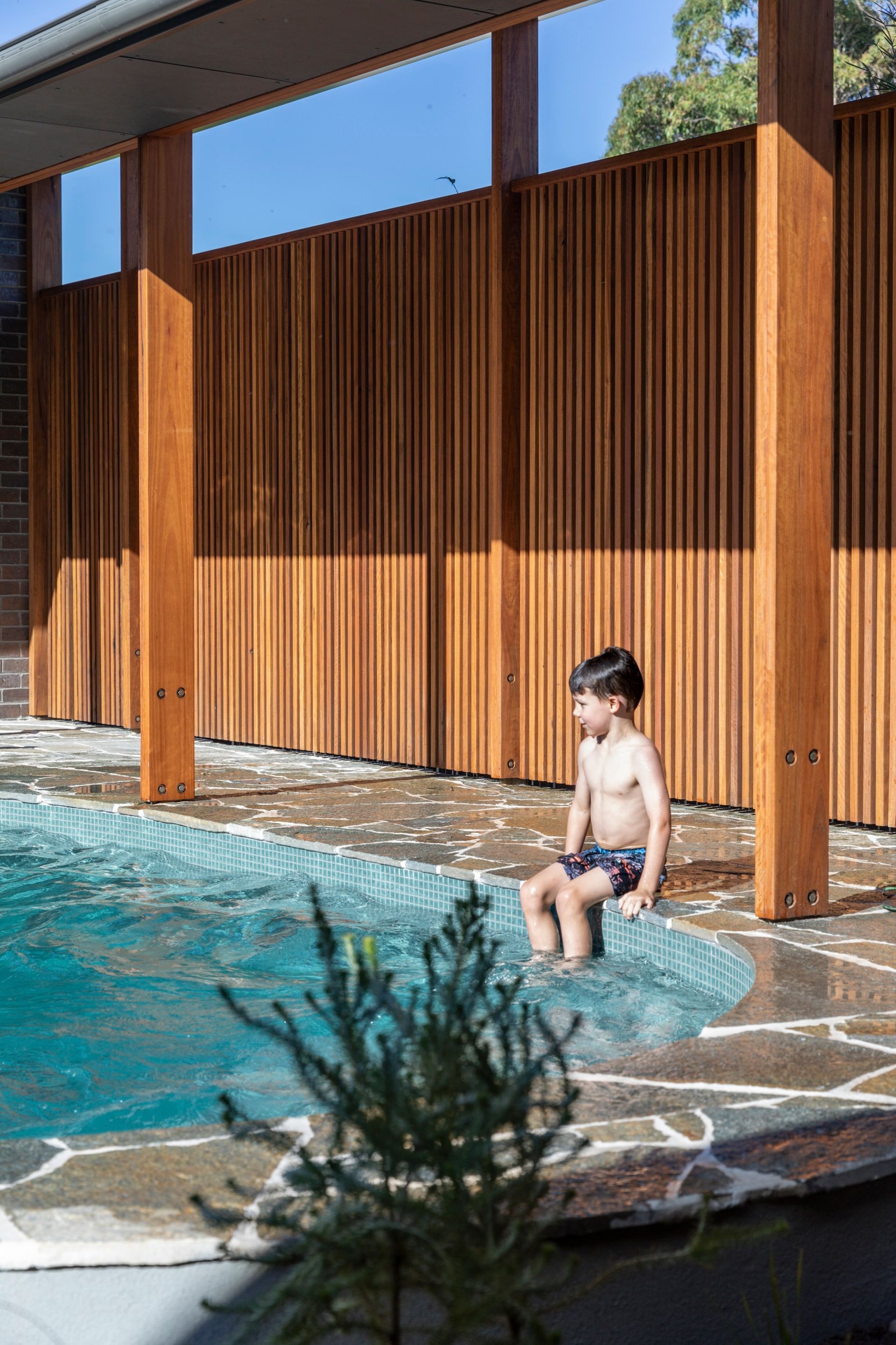 Boy Sitting on Pool Edge — Make The Mark Building Services in Mangerton, NSW
