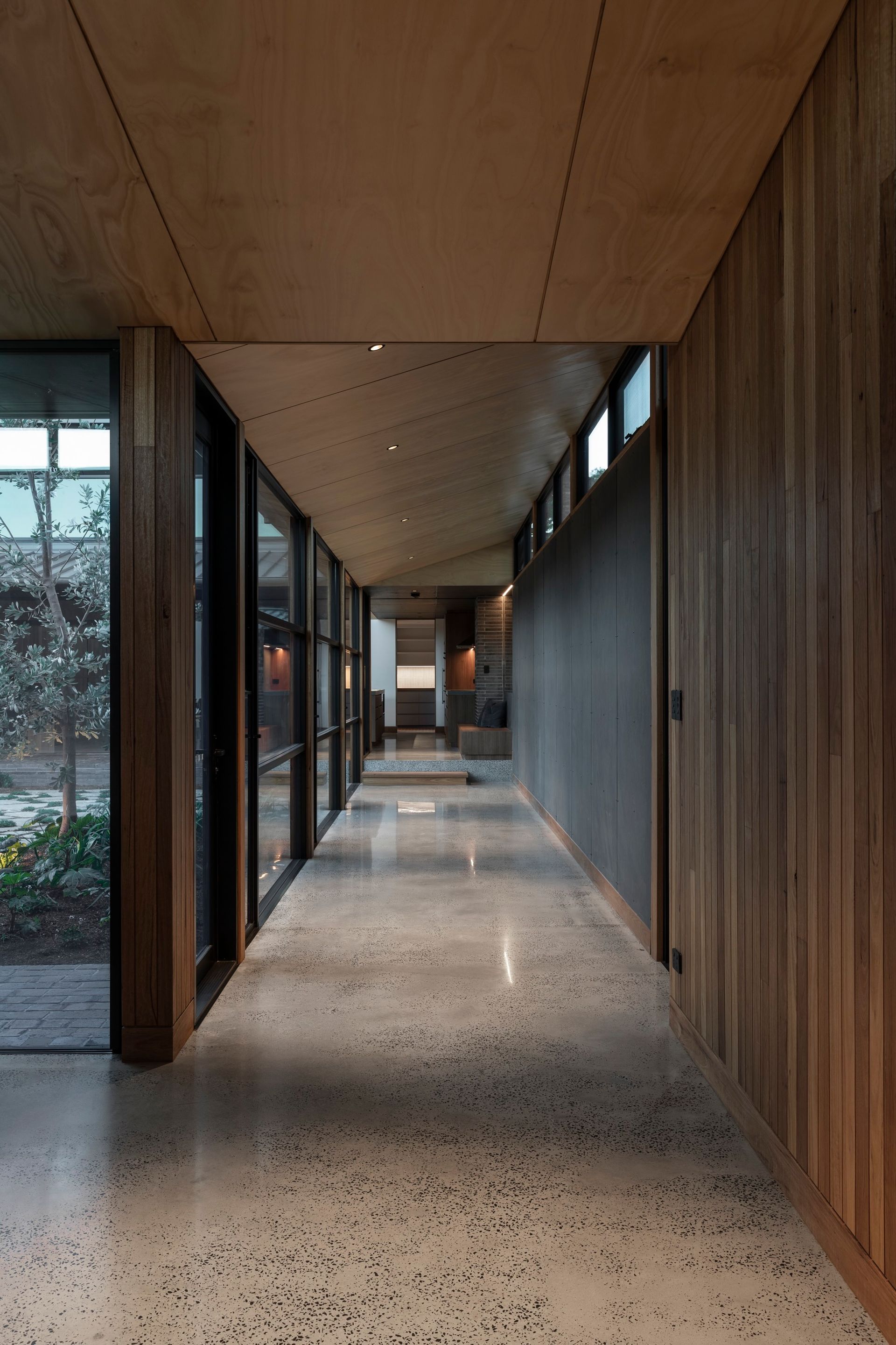 Long, modern hallway with wood paneling, large windows, and terrazzo floor — Make The Mark Building Services in Mangerton, NSW