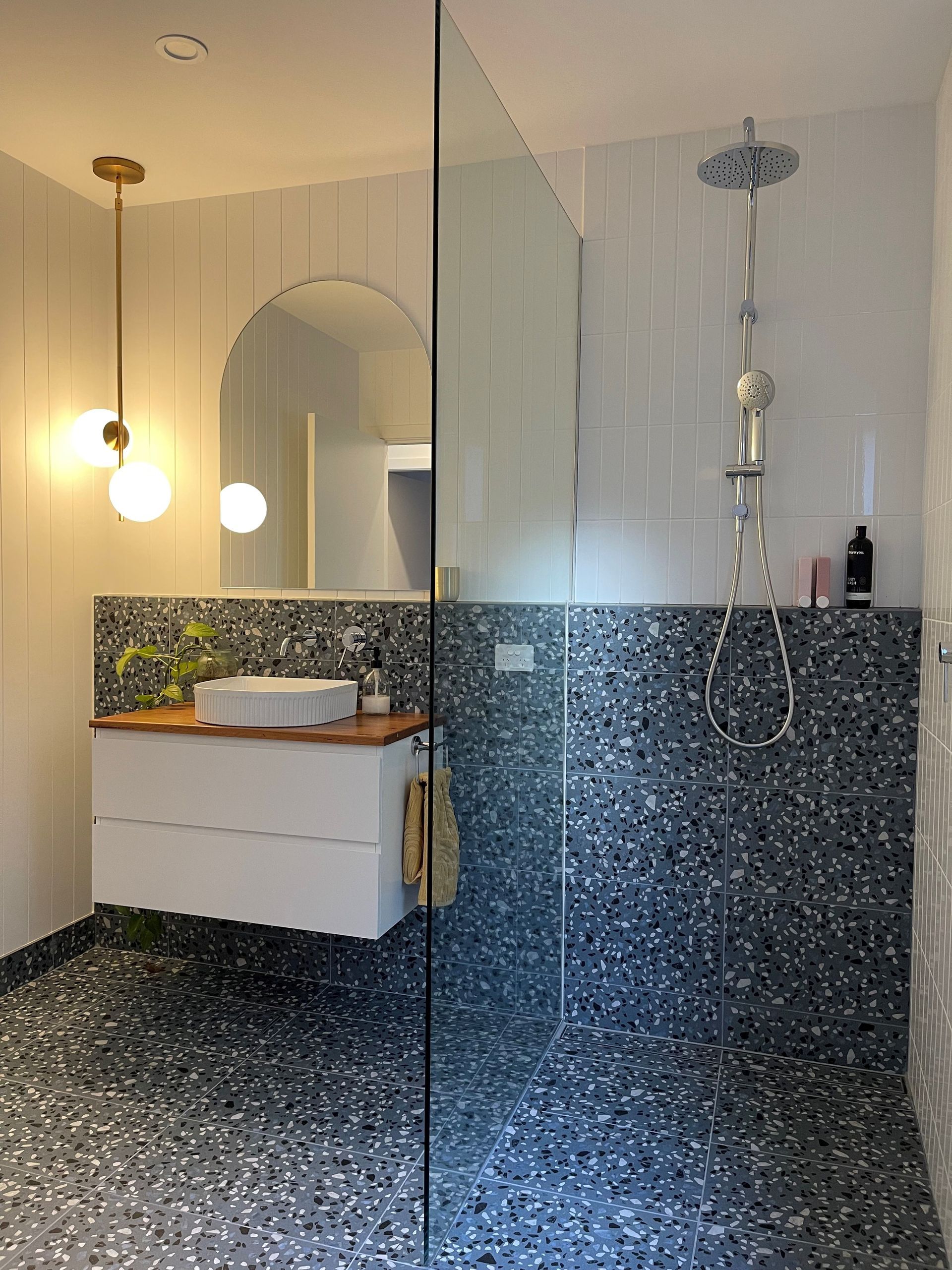 Modern bathroom with a glass shower, terrazzo tile, and a floating vanity - Make The Mark Building Services in Mangerton, NSW