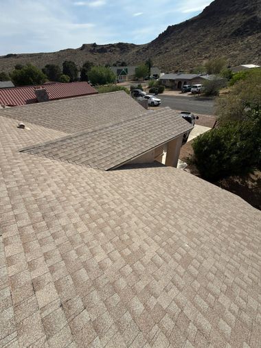 Roof under repair with exposed wooden sheathing and ladders on a house.