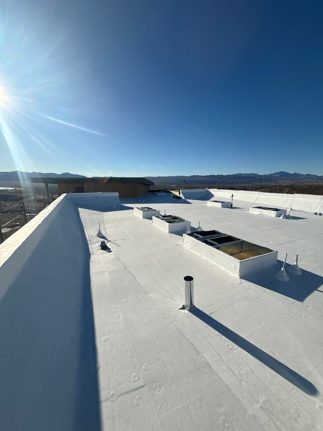 Red clay tiled roof with a dormer window under a blue sky with scattered clouds