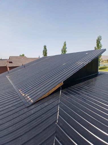 Modern houses with dark roofs and white walls under a clear blue sky