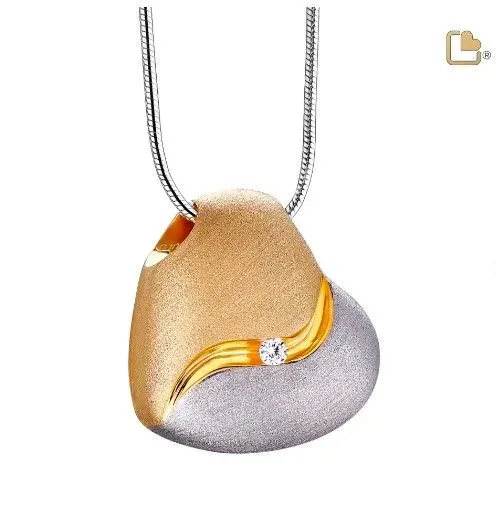 Gold-and-silver heart pendant necklace with a curved gold accent and small gemstone