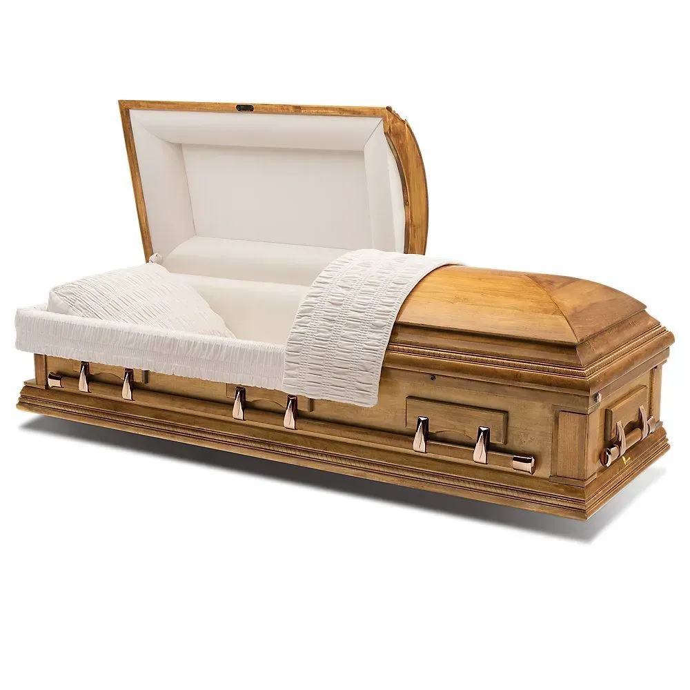 A polished wooden casket with open lid and cream interior, shown with a white lace-trimmed blanket.