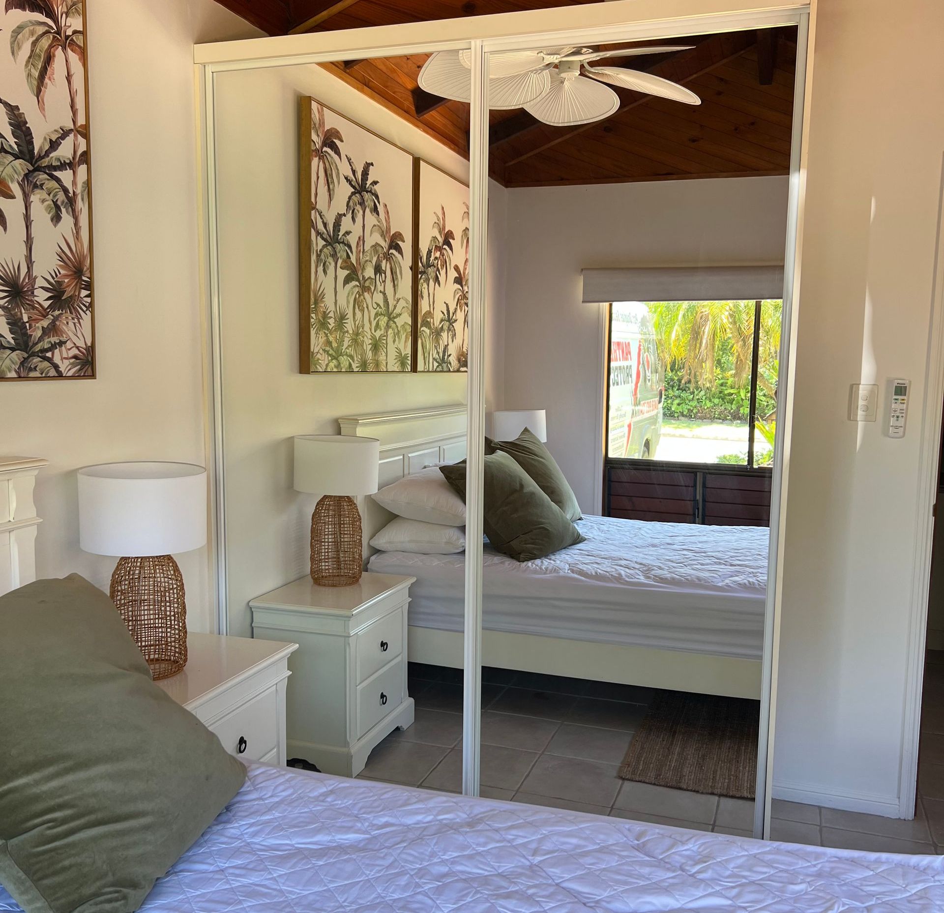 A bedroom with a bed and a ceiling fan