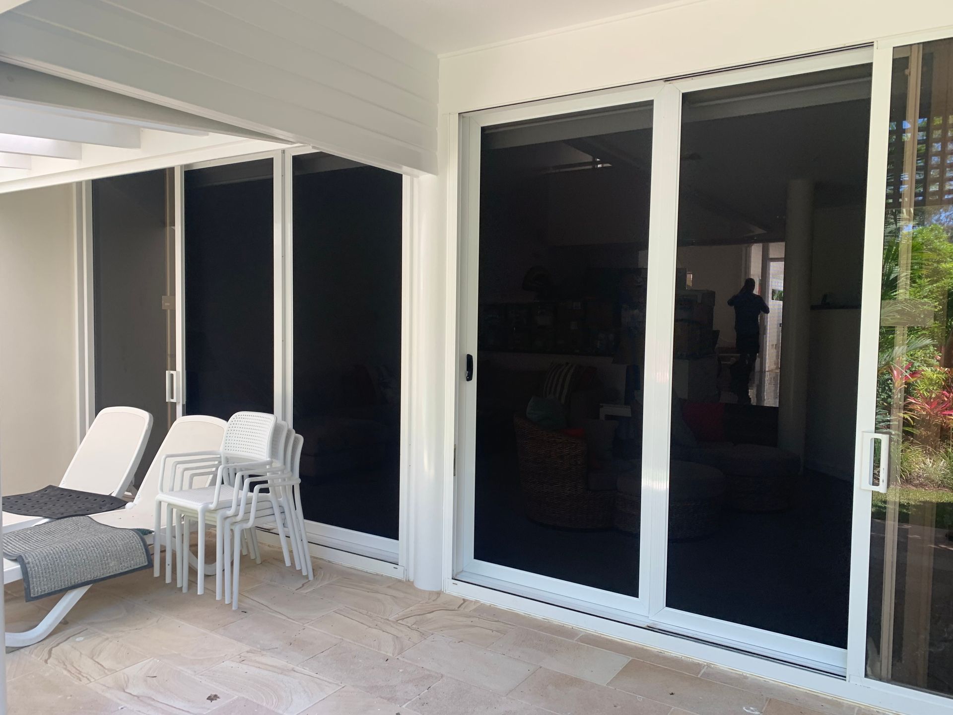 A patio with sliding glass doors and chairs.