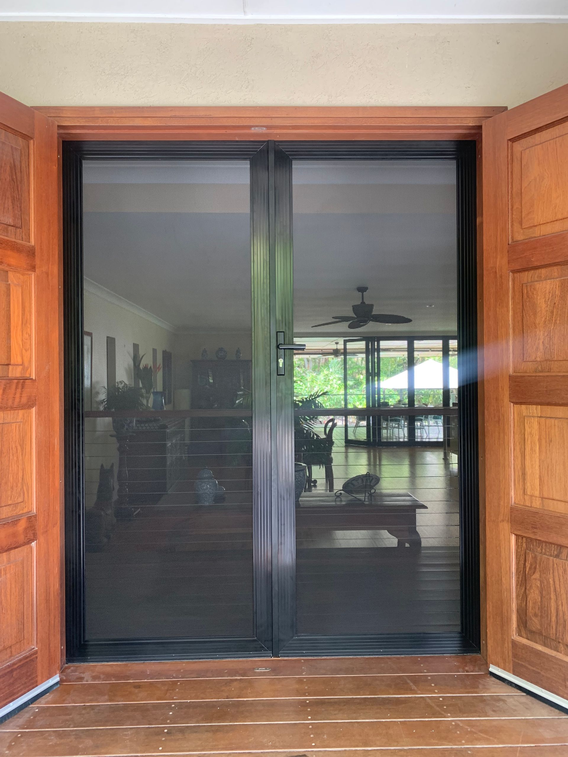 A sliding screen door is open to a living room