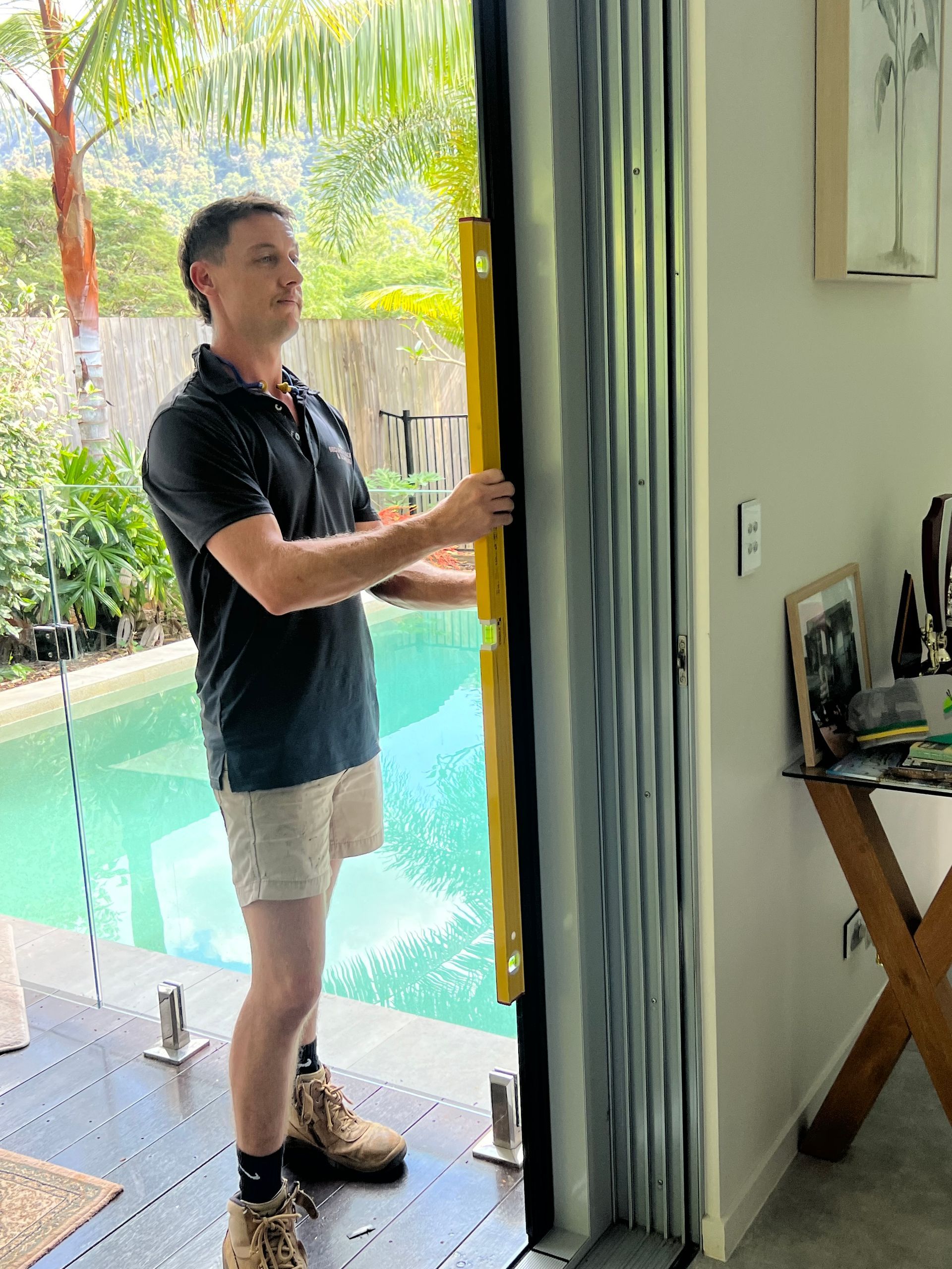 A man is measuring a door with a yellow level.