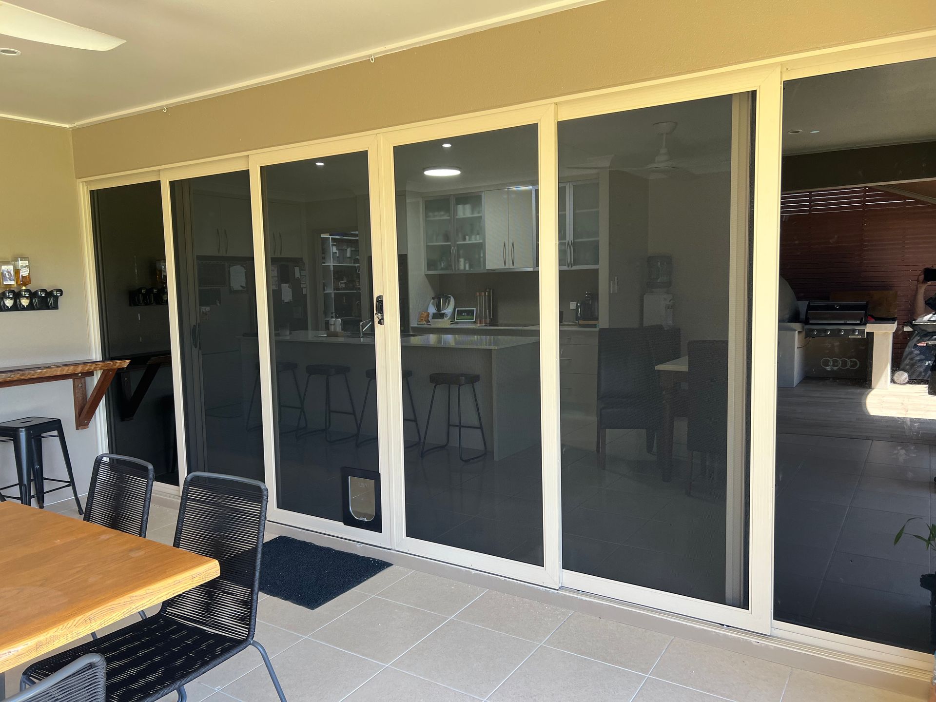 A patio with sliding glass doors and a table and chairs.