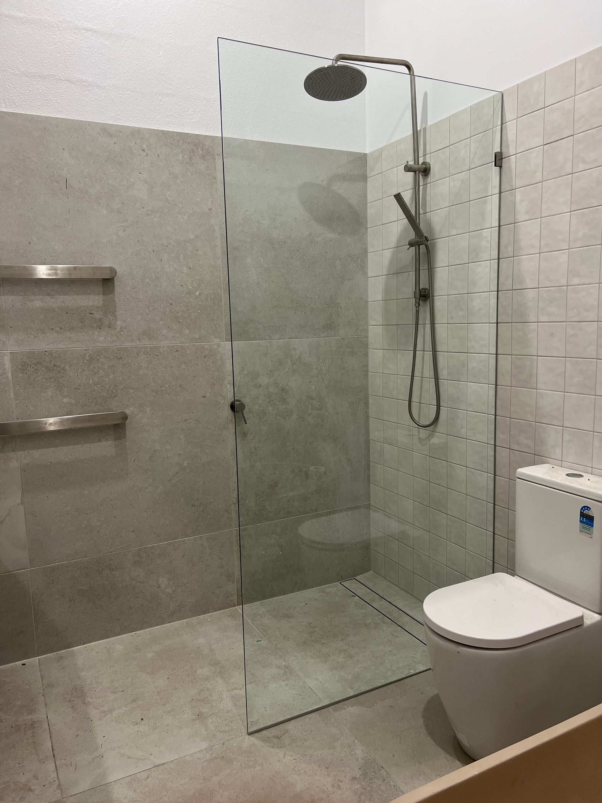 A bathroom with a walk in shower and a toilet.
