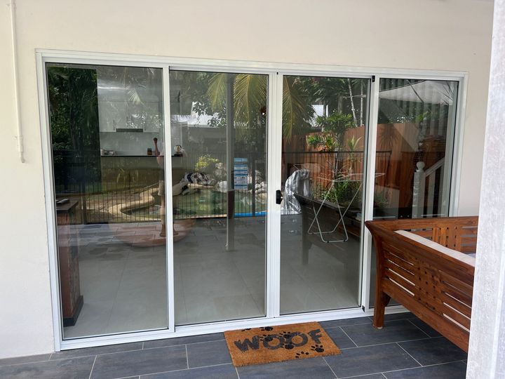 A patio with sliding glass doors and a welcome mat.