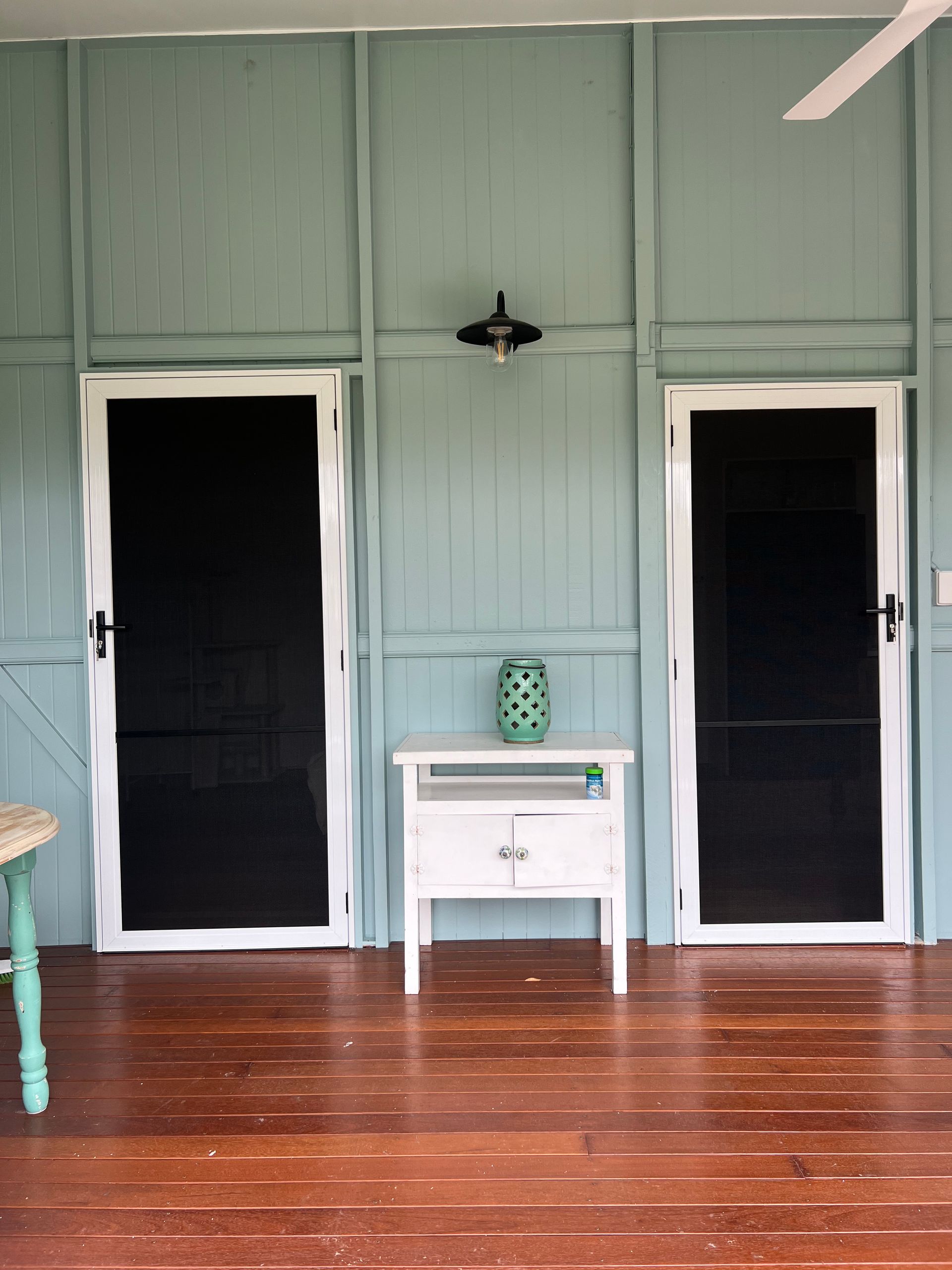 A room with two screened in doors and a table