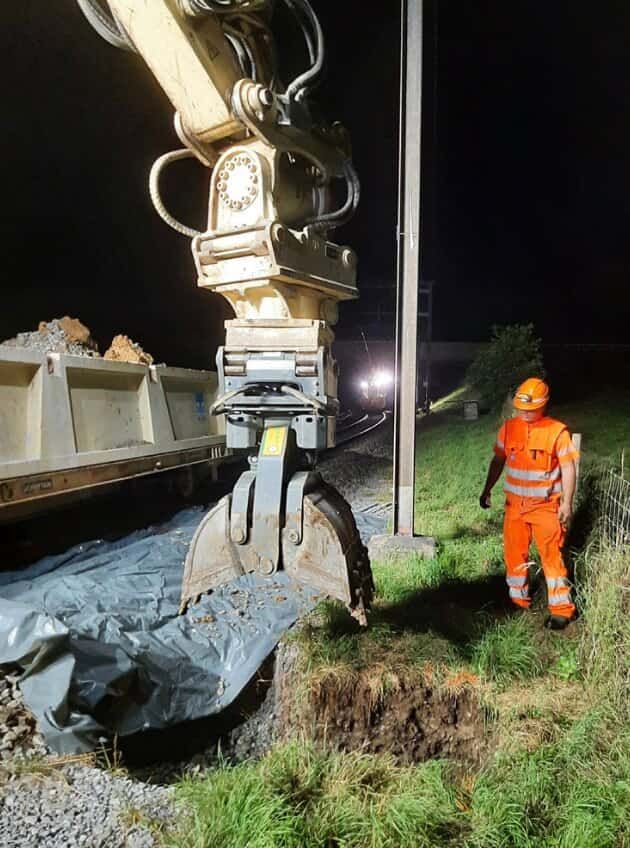 Excavator mast foundation grapple digging foundation holes for rail infrastructure