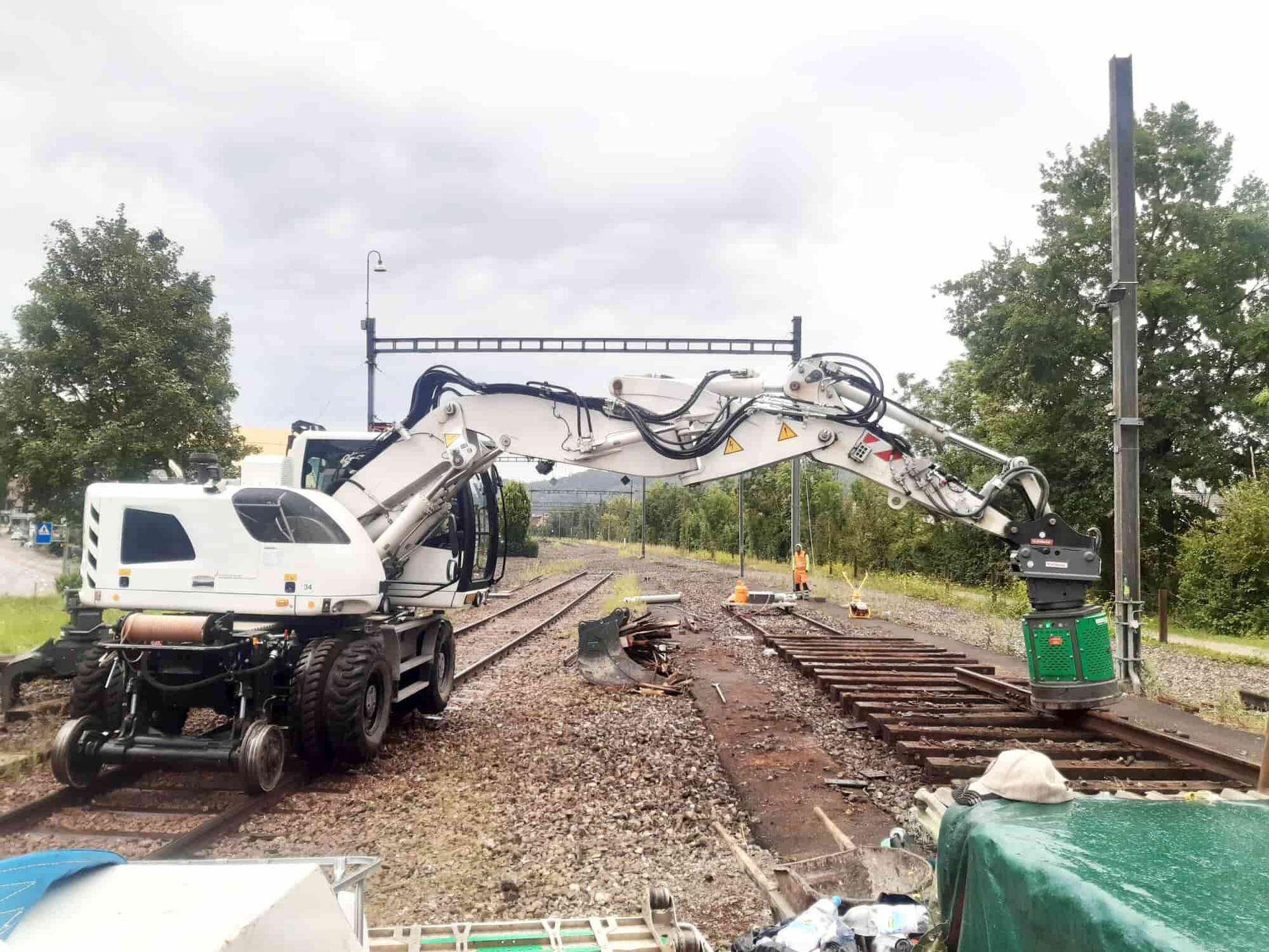 High-rail excavator with Egli hydraulic magnet removing scrap rail from a decommissioned line, supplied by Harrybilt Engineering