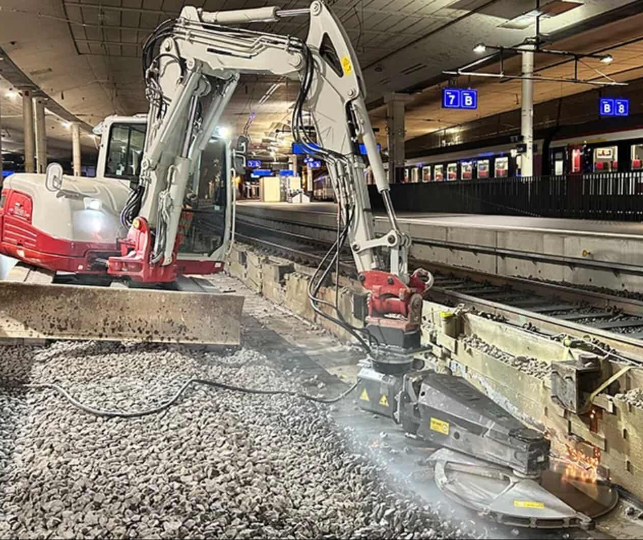 Excavator saw performing precise concrete cutting on rail project