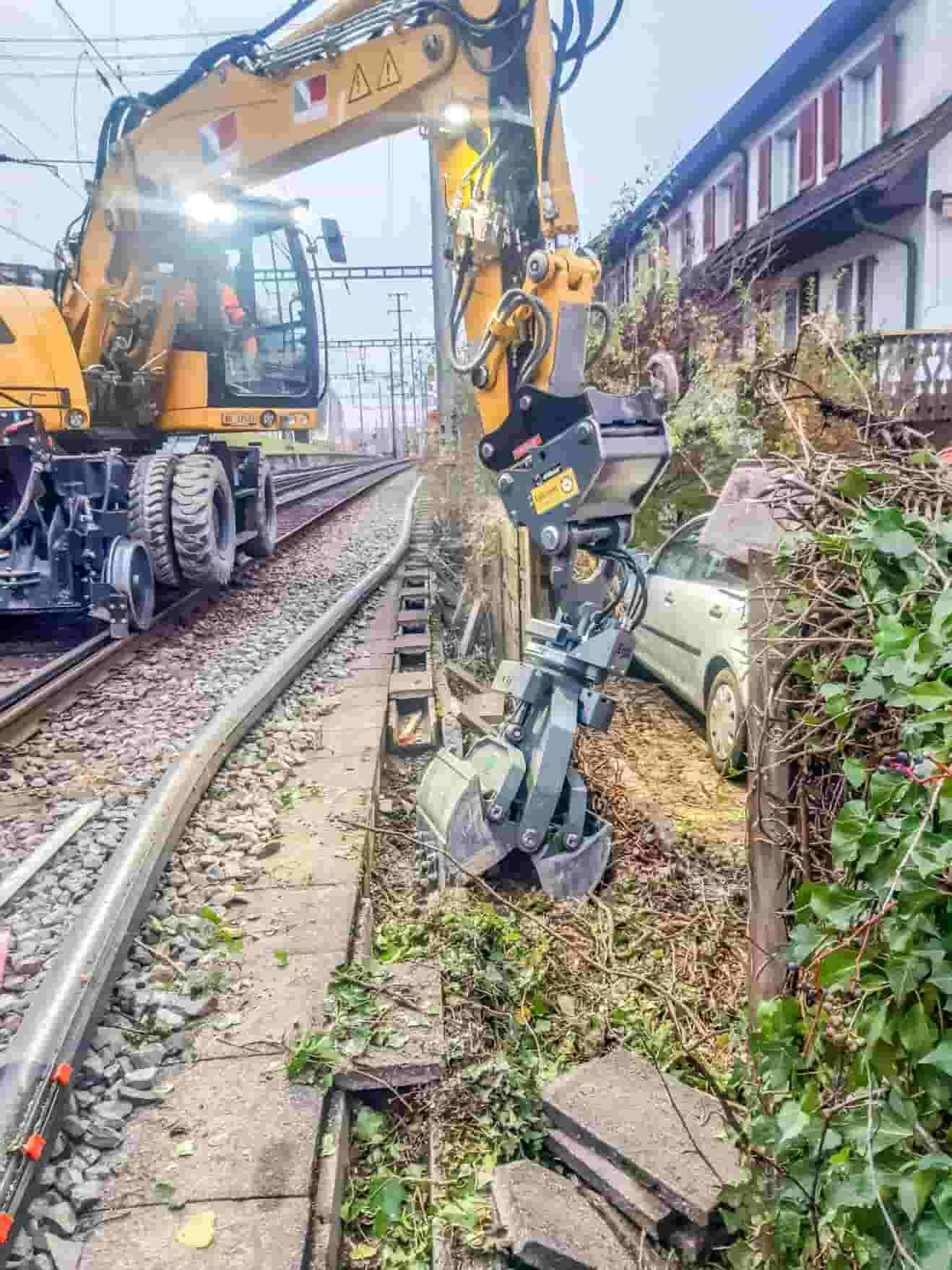 Egli mast foundation grapple digging in confined space between a railway track and fence, supplied by Harrybilt Engineering