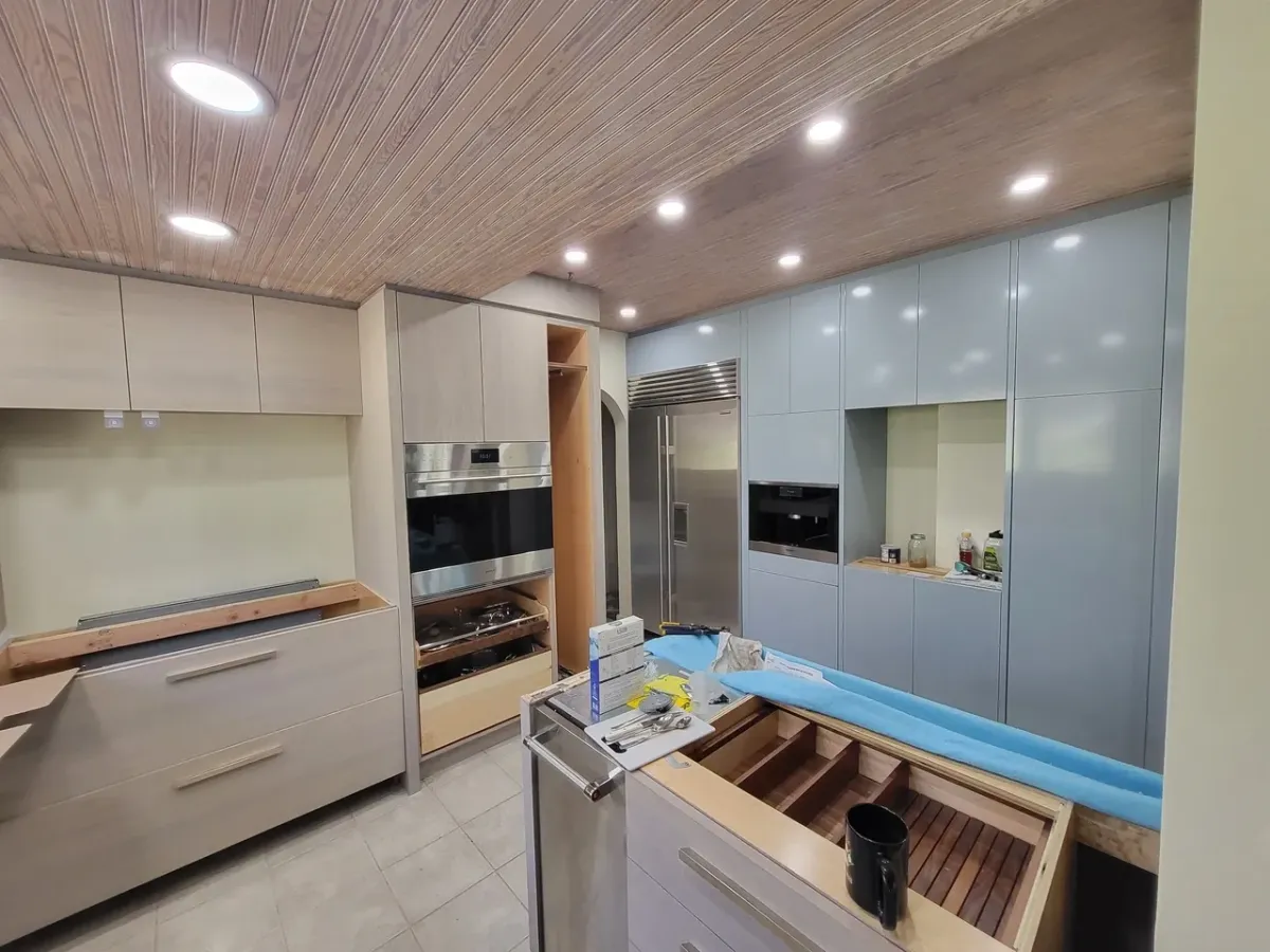 A kitchen with stainless steel appliances and wooden cabinets is being remodeled.