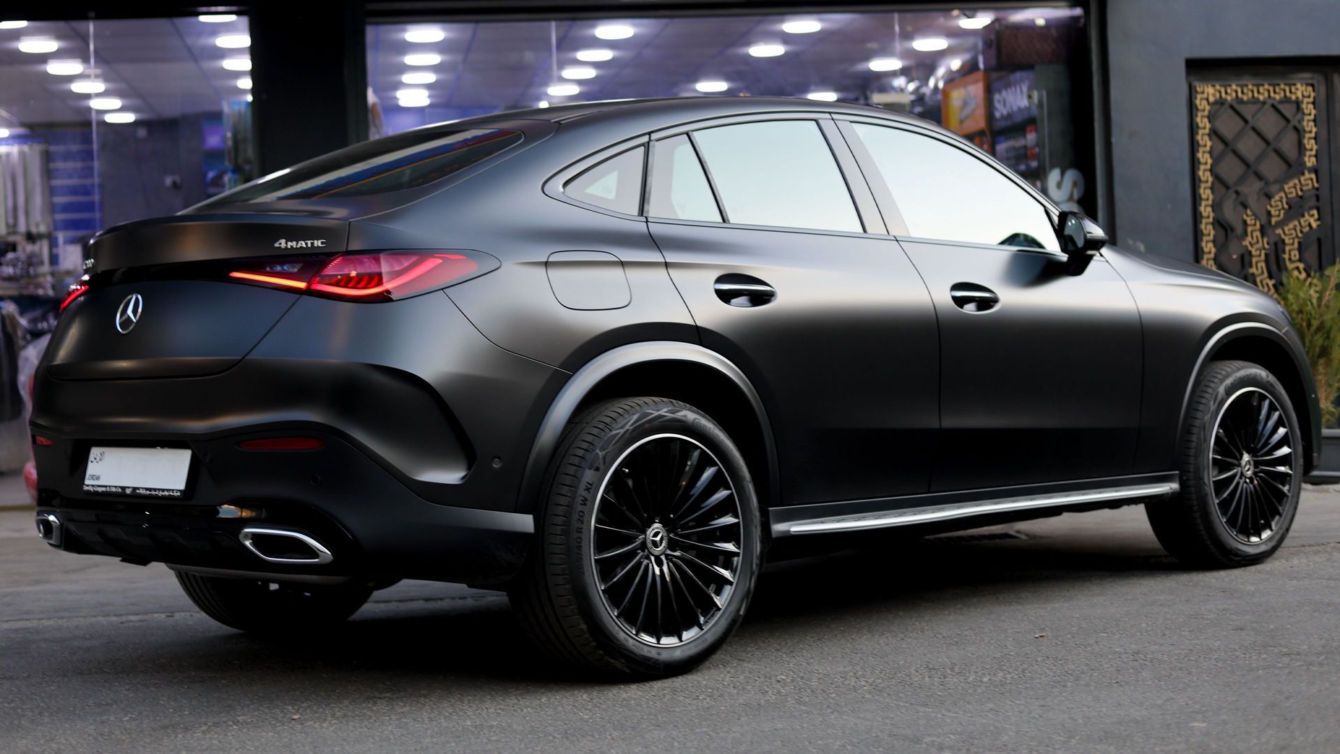 Black luxury SUV parked outdoors at night in front of a lit building