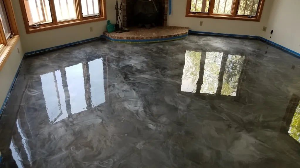 Empty room with glossy gray floor reflecting windows and walls with wood trim