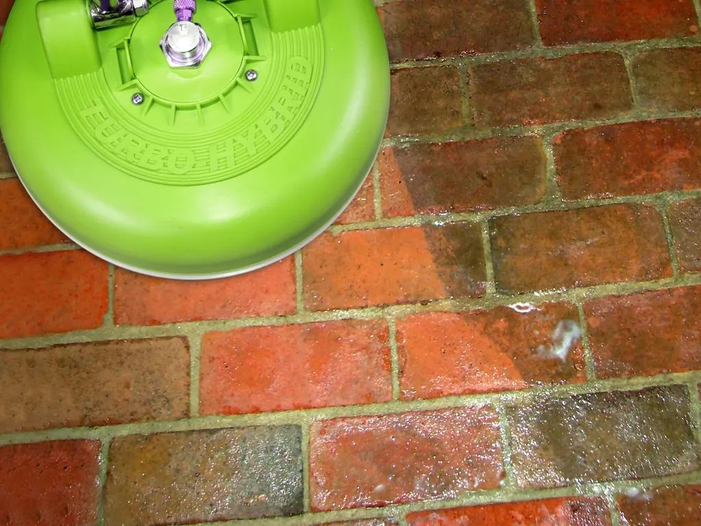 Green circular object on a brick patio, viewed from above.