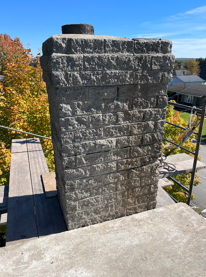 Une cheminée en brique repose sur une plate-forme en béton.